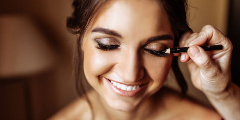 Woman with sparkly makeup having eyeliner applied